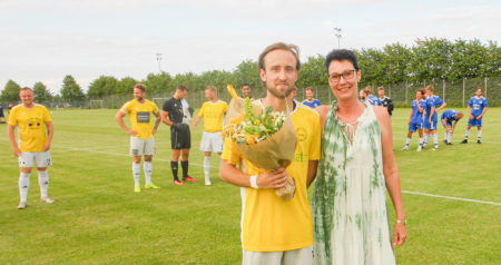 DB-formand, Tina Vexø, overrækker blomster til 100-kampsjubilaren, Peter Ursin. 