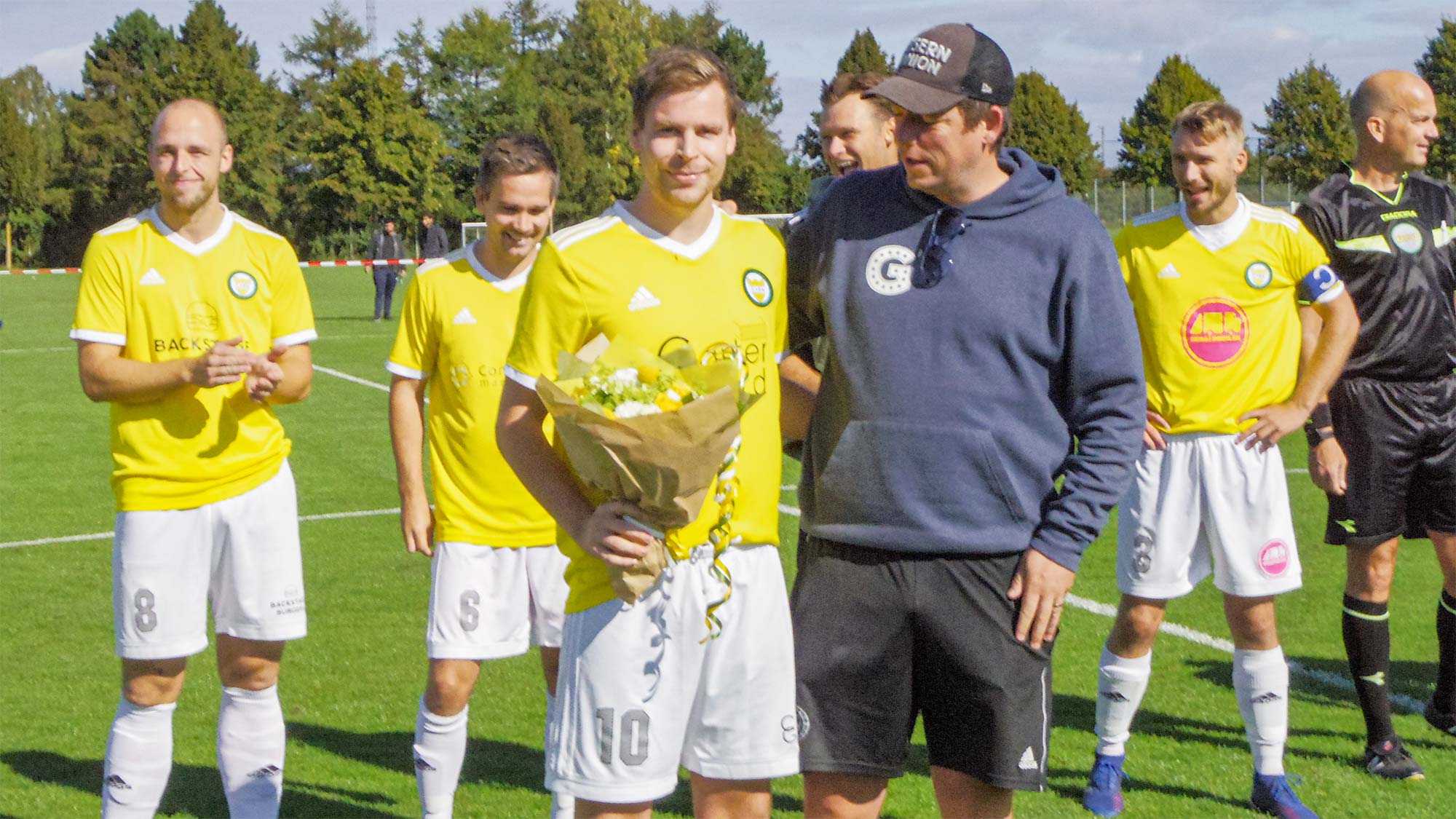 Frederik Glendorf får overrakt blomster af Dragør Boldklubs formand Søren Houen Schmidt.