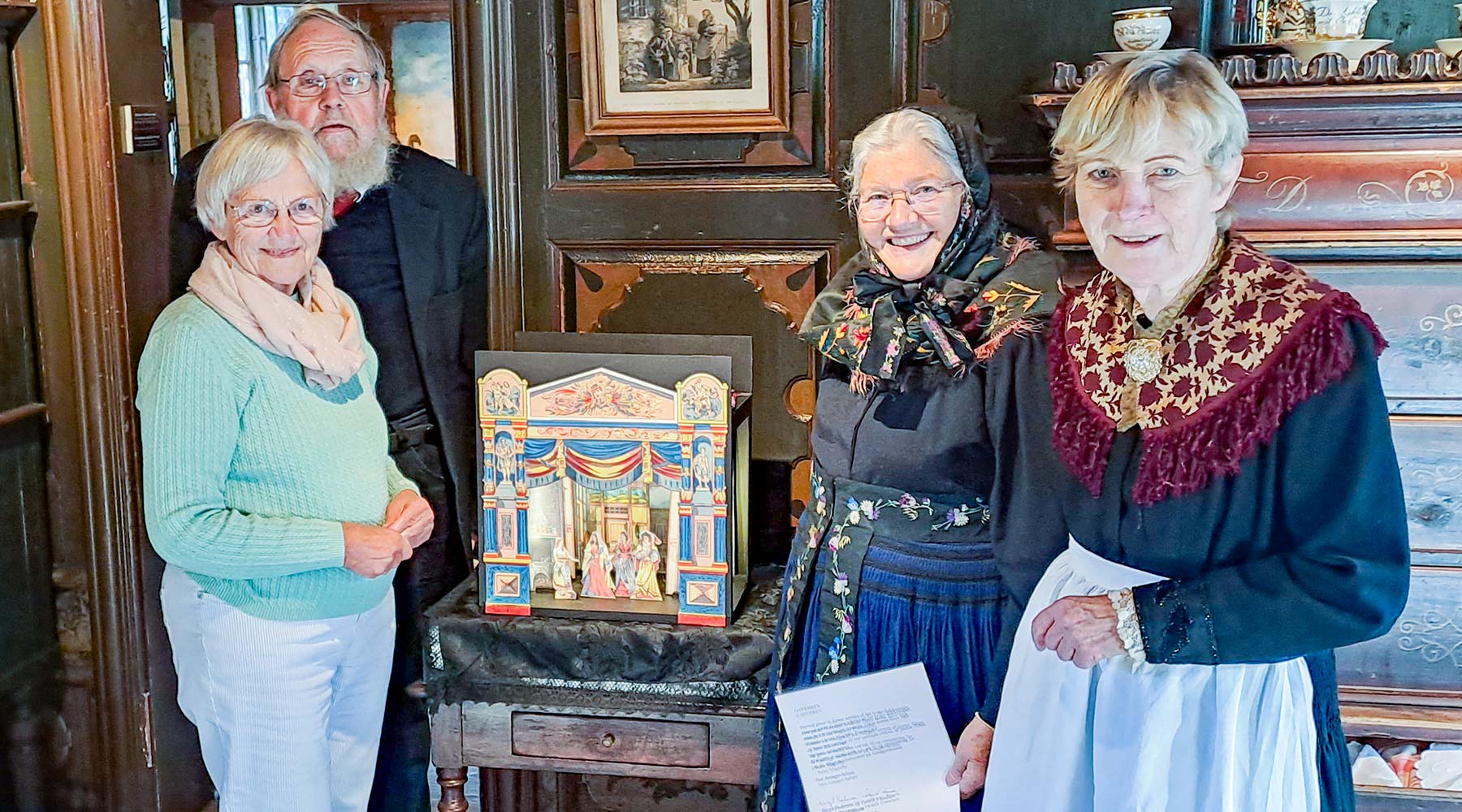Birgit Pedersen og Henrik Frandsen (tv. i billedet) har skabt den smukke dukketeater-kopi, som Majken Pedersen og Nelly Søndergård (th. i billedet) modtager på museets vegne.