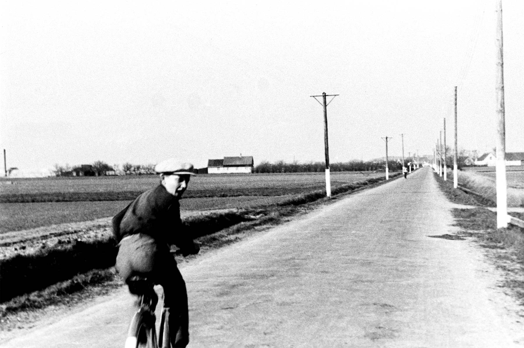 Fælledvej. Cirka 1944–1945. Drengen på cyklen er Helge Stage Christensen. Gartneriet »Tritoma« ses i baggrunden til venstre, og til højre – bag elmasten – ligger Bachersminde. Foto: Historisk Arkiv Drag­ør.