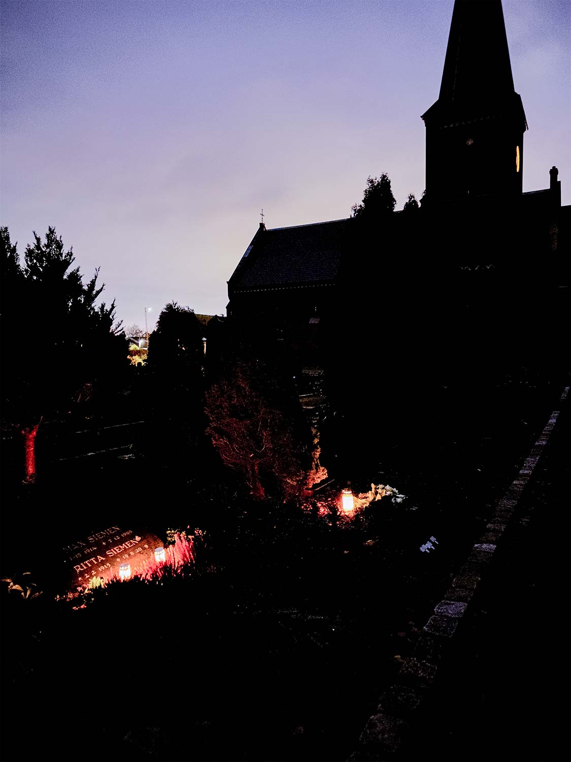 Efter allehelgensgudstjenesten bliver de tændte lys sat ud på gravstederne på Dragør Kirkegård. Foto: TorbenStender.