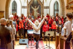 Et veloplagt gospelkor låner kirkerummet og synger i festlig stemning julen ind for et stort publikum. Foto: TorbenStender.