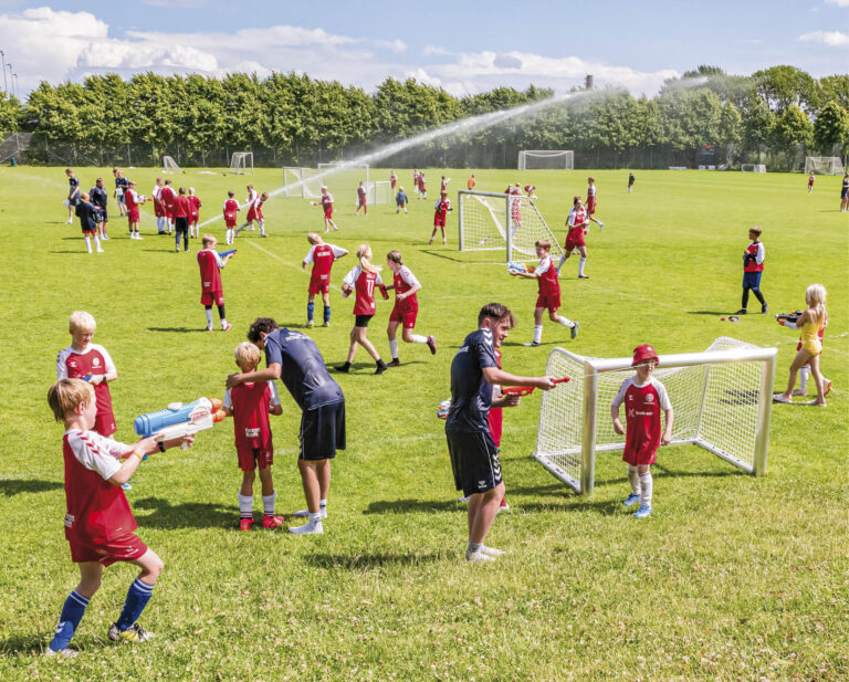 Den lokale udgave af DBU’s fodboldskole, der som altid afvikles på Dragør Boldklubs baner den første uge af skolernes sommerferie, blev i fredags afsluttet med leg og vandkamp. Foto: TorbenStender.