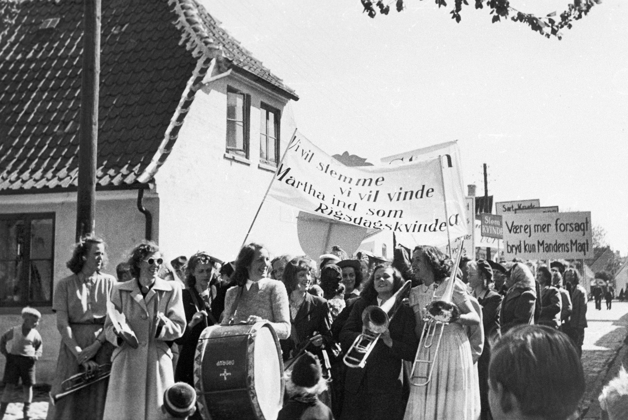 Folk fra Dragør medvirker som statister i optagelser til spillefilmen "Op med lille Martha". Optoget går i Chr. Mølstedsgade.
Huset til venstre er Vestgrønningen 32. Foto: Lokalhistorisk Arkiv Dragør